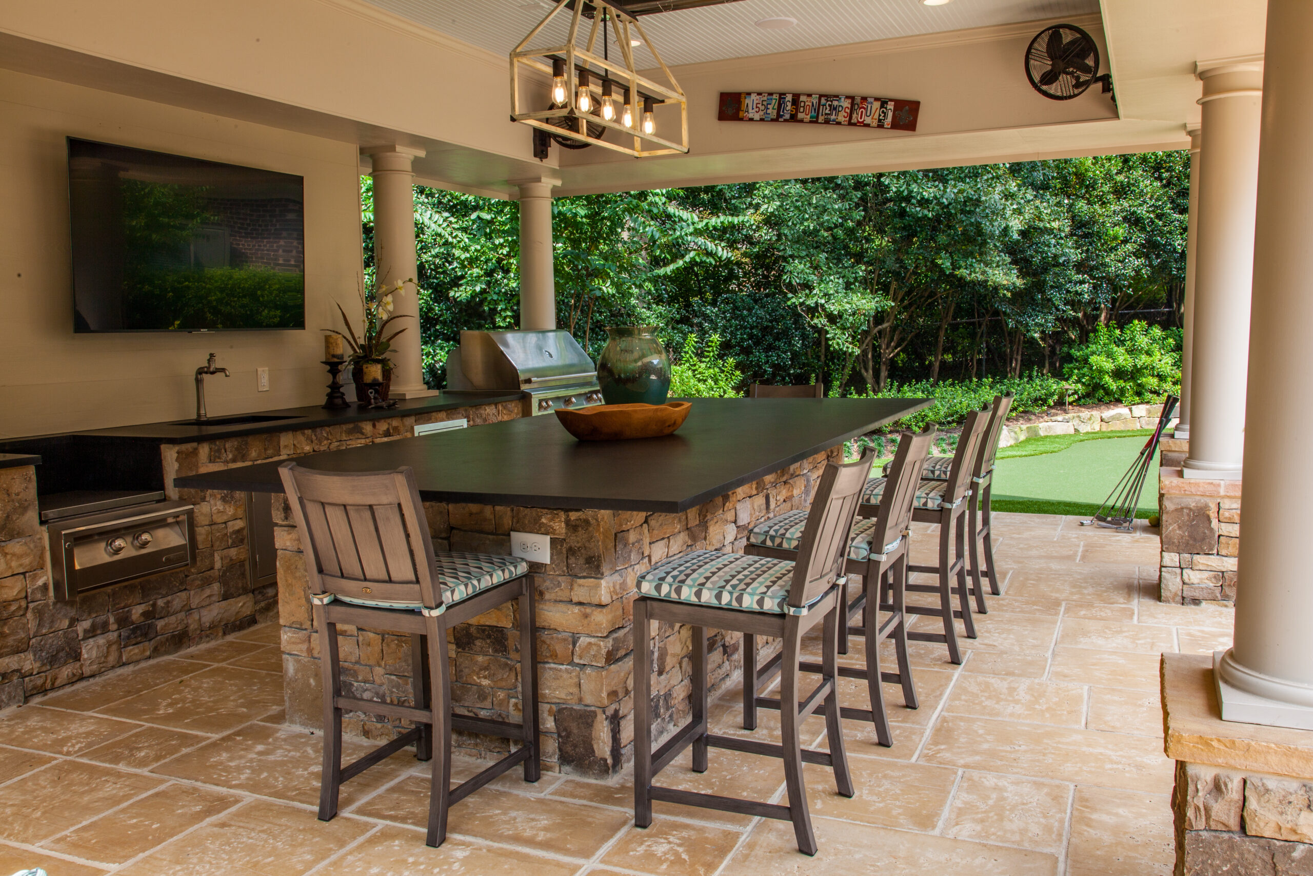 a luxurious outdoor kitchen with seating around an island