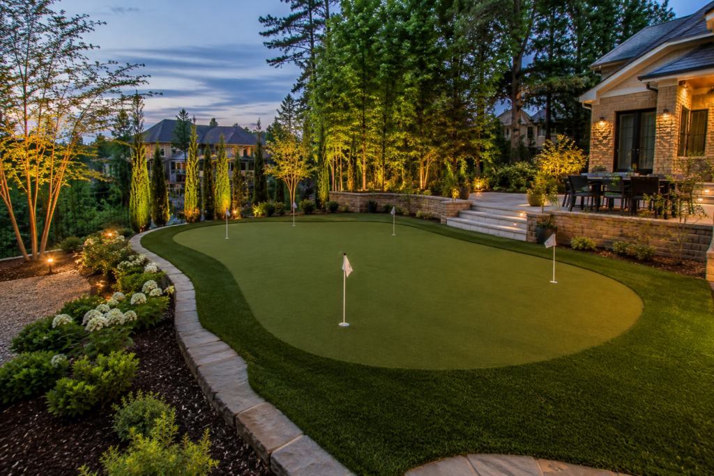 Custom backyard putting green with fringe and stone border at a North Atlanta home.